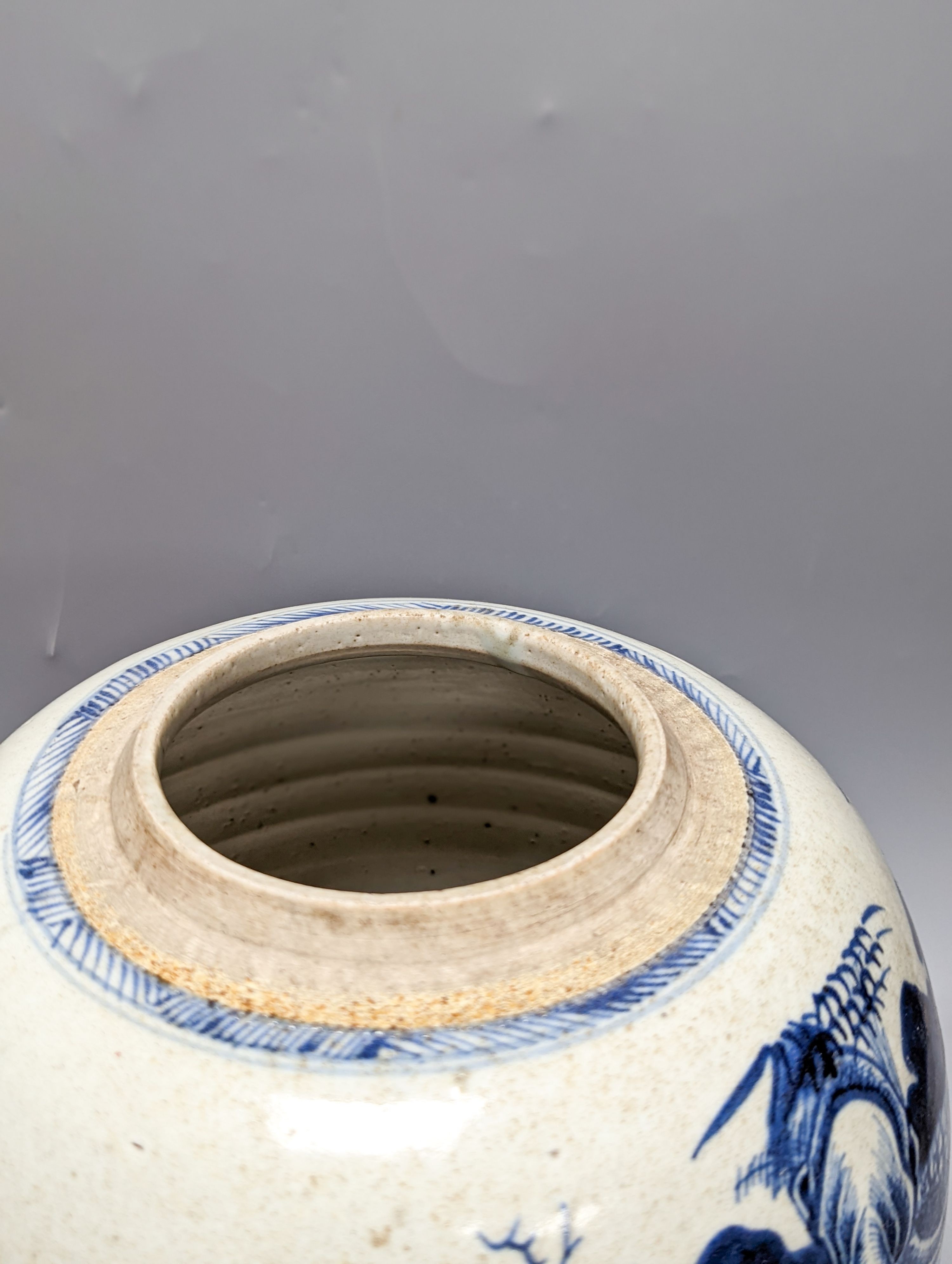 An 18th century Chinese provincial blue and white jar on a wooden stand. 25cm including stand